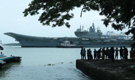 Orang-orang menyaksikan INS Vikrant berangkat untuk uji coba di Laut Arab di Kochi, India, 2 Juli 2022. India pada hari Jumat, 2 September, menugaskan kapal induk buatan dalam negerinya yang pertama dalam usahanya untuk menandingi China yang agresif dengan kapal induk yang jauh lebih besar. armada angkatan laut.