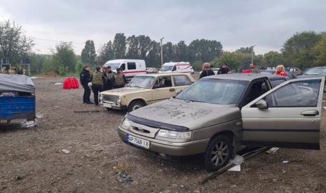 Petugas polisi dan pekerja medis bekerja di dekat mobil yang rusak setelah serangan roket Rusia di Zaporizhzhia, Ukraina, Jumat, 30 September 2022. Serangan Rusia di kota Zaporizhzhia, Ukraina, menewaskan sedikitnya 23 orang dan melukai puluhan lainnya, kata seorang pejabat, Jumat. hanya beberapa jam sebelum Moskow berencana untuk mencaplok lebih banyak Ukraina dalam eskalasi perang tujuh bulan.