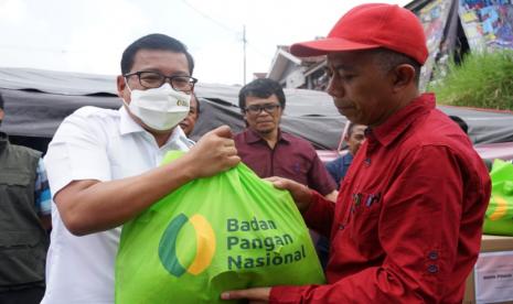 Kepala Badan Pangan Nasional/National Food Agency (NFA) Arief Prasetyo Adi saat menyalurkan kebutuhan pokok (sembako) bagi korban gempa Cianjur sekaligus meninjau Dapur Pangan B2SA (Beragam, Bergizi Seimbang, dan Aman) di Desa Cibeureum, Cugenang Cianjur, Selasa, (6/12/2022). Aksi ini sebagai upaya menjaga kebutuhan pangan dan gizi para pengungsi gempa Cianjur.