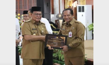 Gubernur Kalsel H Sahbirin Noor menyerahkan piagam penghargaan   SKPD Paling Informatif kepada Kepala Badan Penanggulangan Bencana Daerah (BPBD) Provinsi Kalsrl, Raden Suria Fadliansyah , di Mahligai Pancasila Senin (23/10/2023).