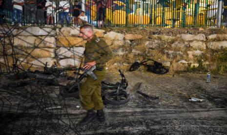 Tentara Israel melintasi area yang terkena roket yang menewaskan banyak anak dan remaja di lapangan sepak bola di kota Druze Majdal Shams, di Dataran Tinggi Golan yang dianeksasi Israel, Sabtu, 27 Juli 2024. 