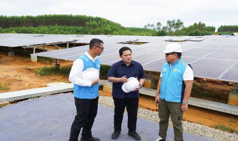 Menteri BUMN Erick Thohir (tengah) diskusi bersama Wakil Menteri BUMN Kartika Wirjoatmodjo (kanan) dan Direktur Utama PLN Darmawan Prasodjo (kiri) saat mengunjungi pembangkit listrik tenaga surya (PLTS) IKN, di Penajam Paser Utara, Kalimantan Timur, Sabtu (29/6/2024).