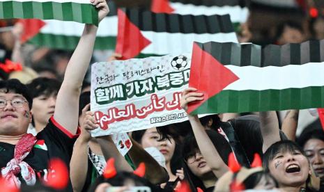 Penggemar Korea Selatan mengibarkan bendera Palestina selama pertandingan di Stadion Piala Dunia Seoul pada 5 September 2024 