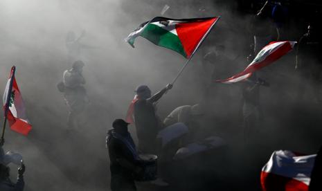 Demonstran pro-Palestina mengibarkan bendera dalam unjuk rasa di Ottawa, Ontario, Sabtu, 5 Oktober 2024.