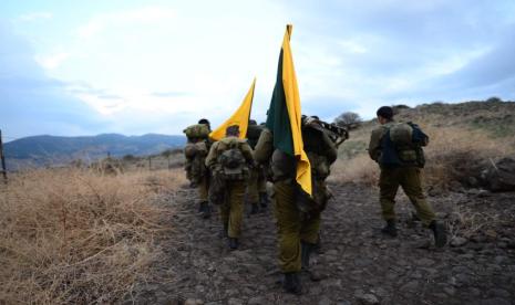 Anggota Brigade Golani dengan panji kuning berbaris di perbatasan Israel-Gaza. 