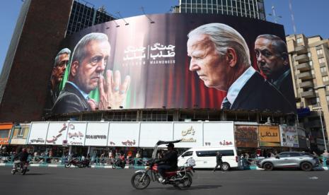 Papan reklame anti-Israel dan Amerika Serikat di di Lapangan Valiasr di Teheran, Iran, 27 Oktober 2024.  Presiden AS Joe Biden dan PM Israel Benjamin Netanyahu ditulis sebagai Penghasut Perang di reklame itu.