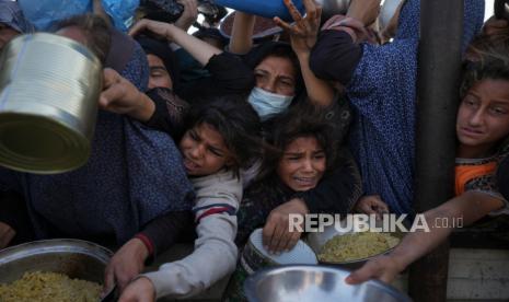 Gadis dan perempuan Palestina berjuang untuk mendapatkan makanan di pusat distribusi di Khan Younis, Jalur Gaza Jumat, 6 Desember 2024.  Agresi Israel telah menyebabkan kelaparan parah di Jalur Gaza.