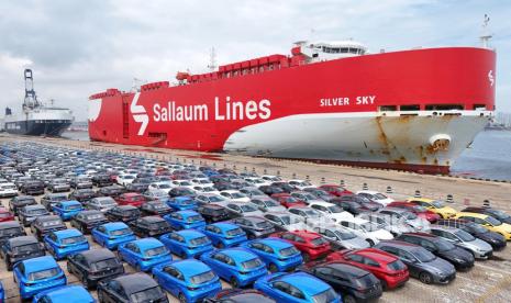 Mobil-mobil baru menunggu transportasi di dekat kapal ro-ro Sallaum Lines yang terlihat di dermaga di Yantai di provinsi Shandong, China timur pada Selasa, 6 Agustus 2024.