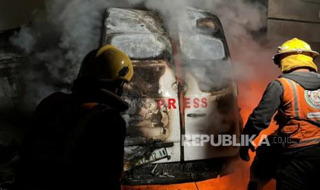 Pekerja darurat Pertahanan Sipil Palestina memadamkan api di van berisi lima jurnalis di sekitar Rumah Sakit al-Awda di Nuseirat di Gaza tengah, 26 Desember 2024 