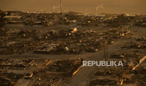 Seseorang berjalan melalui lingkungan yang hancur akibat Kebakaran di bagian Pacific Palisades di Los Angeles, Jumat, 10 Januari 2025. 