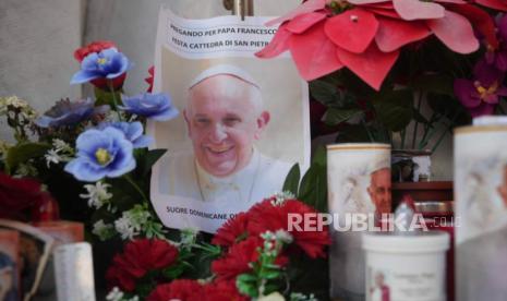 Lilin terlihat di dekat foto Paus Fransiskus di luar Poliklinik Agostino Gemelli di Roma, Ahad, 23 Februari 2025, tempat Paus dirawat di rumah sakit sejak 14 Februari.