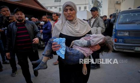 Seorang wanita membawa jenazah seorang anak ke rumah sakit Al-Ahli menyusul serangan udara Israel semalaman di Jalur Gaza, di Kota Gaza, Selasa, 18 Maret 2025. 