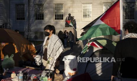 Seorang mahasiswa berdiri di depan patung John Harvard, dermawan besar pertama Harvard College, dalam aksi protes perang di Gaza, di Universitas Harvard di Cambridge, 25 April 2024.