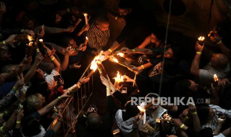 Peziarah Kristen memegang lilin saat upacara Api Kudus, di Gereja Makam Suci, di Kota Tua Yerusalem, Sabtu, 19 April 2025.