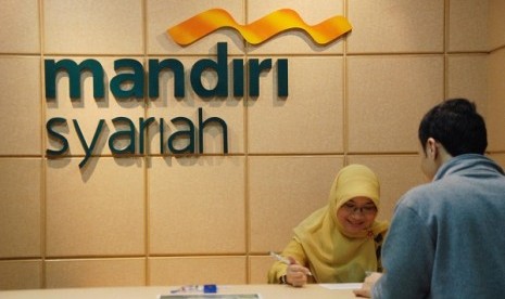 A bank teller in Mandiri Sharia deals with a customer in Jakarta. Government plans to establish a state owned sharia bank. (illustration) 