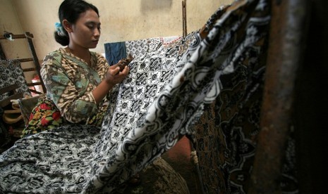 A batik artisan works in a batik workshop Paoman Art, Indramayu, West Java. (illustration)