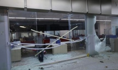 A Benghazi TV (BTV) employee inspects damage in the television station's studios after an artillery shell landed on its roof, in Benghazi July 9, 2014. 