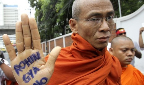 A Buddhist monk shows a message written in his palm to protest against the ethnic minority Rohingyas in Myanmar during a visit of Myanmar's President Thein Sein in Bangkok, Thailand, Tuesday, July 24, 2012. Communal violence is grinding on in western Myanm