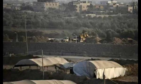   A bulldozer looks over smuggling tunnels along the border with Egypt as seen from Rafah, southern Gaza Strip, Sunday, Sept. 1, 2013.