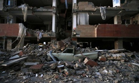 A car lays smashed by debris from the earthquake at the city of Sarpol-e-Zahab in western Iran, Monday, Nov. 13, 2017. A powerful earthquake shook the Iran-Iraq border late Sunday, killing more than two hundred people and injuring some 800 in the mountainous region of Iran alone, state media there said.