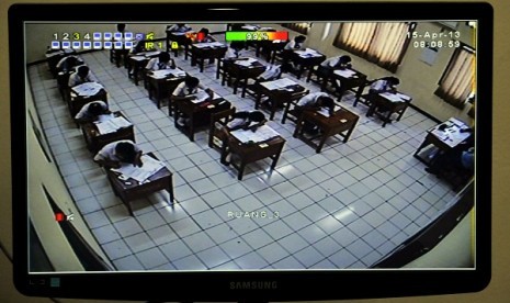 A CCTV helps teacher to monitor students doing their national exam at a vocational school in Jakarta, Monday. 