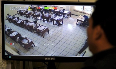 A CCTV helps teacher to watch students doing their national exam at a vocational school in Jakarta, Monday. 