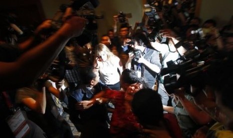 A Chinese family member of a passenger onboard the missing Malaysia Airlines Flight MH370 screams as she is being brought into a room outside the media conference area at a hotel in Kuala Lumpur International Airport March 19, 2014.