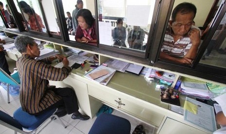 A civil servant (left) wears traditional cloth while providing service in the cityhall of Solo, Central Java. (illustration)  