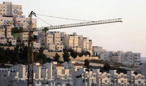 A crane is seen next to homes in a Jewish settlement near Jerusalem known to Israelis as Har Homa and to Palestinians as Jabal Abu Ghneim January 3, 2014.