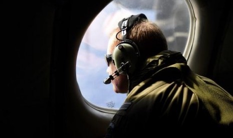 A crew member looks out an observation window aboard a Royal New Zealand Air Force (RNZAF) P3 Orion maritime search aircraft as it flies over the southern Indian Ocean on Saturday.