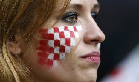 A Croatian fan with her face painted in national colours is pictured before their Group C Euro 2012 soccer match against Italy at the city stadium in Poznan, Thursday. Euro fever also hits Indonesia, as many football lovers do not mind to stay awake during