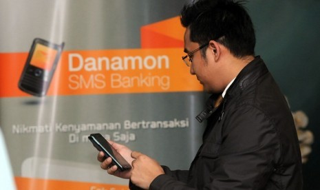 A customer tries sms banking service provided by Bank Danamon in Jakarta, this week. 