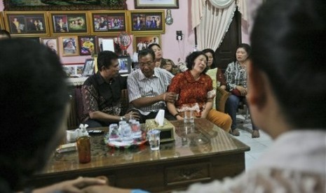 Chrisman Siregar (center) and his wife Herlina Panjaitan (right) are at their residence in Medan, North Sumatra, Indonesia, Sunday, March 9, 2014. Their son, Firman Siregar, was registered on the manifest to have boarded the Malaysia Airlines jetliner flight MH 370.