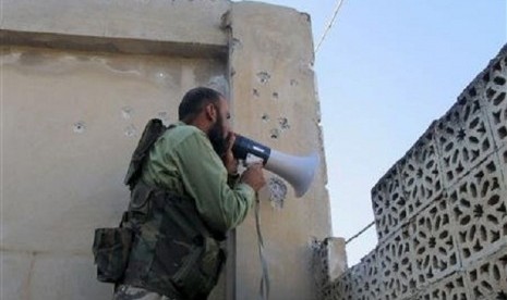 A Free Syrian Army fighter calls on Syrian regime troops to defect in the Khan al-Assal area, near Aleppo April 27, 2013. 