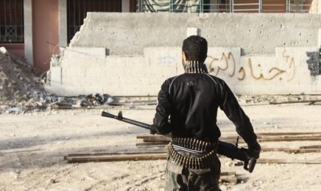 A Free Syrian Army fighter carries his weapon on one of the battlefronts in Jobar, a suburb of Damascus February 22, 2014.