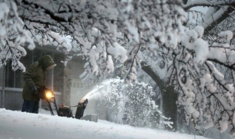 A local resident clears snow from his driveway after an overnight snowfall left many schools and businesses closed for the day, Thursday, Dec. 20, 2012, in Urbandale, Iowa. 