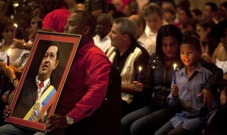 A man holds a framed image of Venezuela's President Hugo Chavez during a Mass to pray for the recovery of Chavez at the Cathedral, in Havana, Cuba, Saturday, Jan. 12, 2013. The 58-year-old president is fighting a severe respiratory infection a month after 