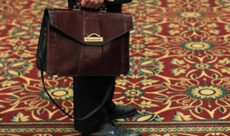 A man holds his briefcase while waiting in line during a job fair in Melville, New York July 19, 2012.