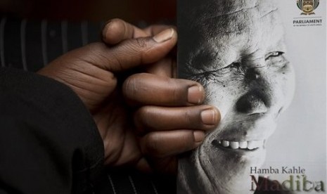 A man holds the official programme ahead of the memorial service for former South African president Nelson Mandela at the FNB Stadium in the Johannesburg, South Africa township of Soweto, Tuesday, Dec. 10, 2013. 