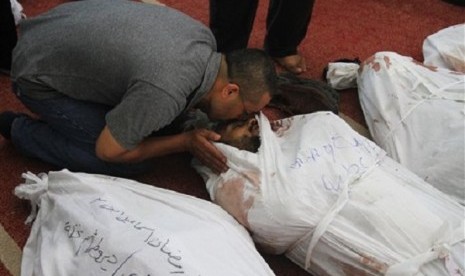 A man kisses the body of a supporter of ousted President Mohammed Mursi at the El-Iman mosque in Cairo's Nasr City, Egypt, Thursday, Aug. 15, 2013. 