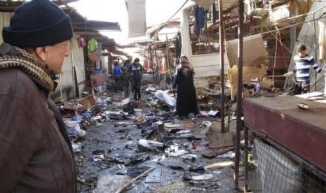 A man looks at the site of bomb attack at a marketplace in Baghdad's Doura District December 25 2013.