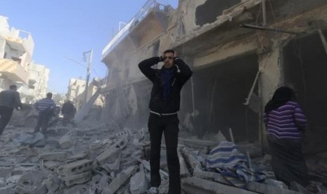 A man reacts at a site hit by what activists said were explosive barrels thrown by forces loyal to Syria's President Bashar al-Assad in the Al-Haidariya neighbourhood of Aleppo February 12, 2014.