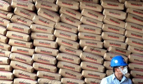 A man stands with a stack of cement sacks produced by PT Semen Gresik in Tuba, East Java. (illustration)  