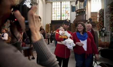 A man takes a picture of a guard holding a baby in the Nieuwe Kerk church the day after the investiture of King Willem-Alexander in Amsterdam May 1, 2013. Thousands of people took the opportunity to see the interior of the church which was used for the cer