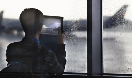 A man tries to photograph a supposed Aeroflot flight to Havana through a window of Sheremetyevo airport outside Moscow, Russia, Monday, July 8, 2013. NSA leaker Edward Snowdon is believed to be stuck in the transit zone of the airport since his arrival on 