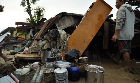 A man tries to save his belongis after his house hit by flash flood in Parigi Moutong, Central Sulawesi.  