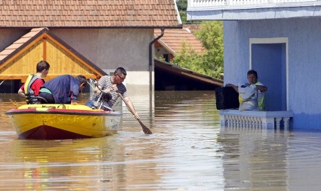 A man waits to be rescued from his house during heavy floods in Vojskova, May 19, 2014. 