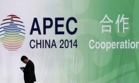 A man walks past a wall bearing a logo of the 2014 Asia Pacific Economic Cooperation (APEC) at the venue for APEC CEO Summit while its opening ceremony is being held in Beijing November 9, 2014. 