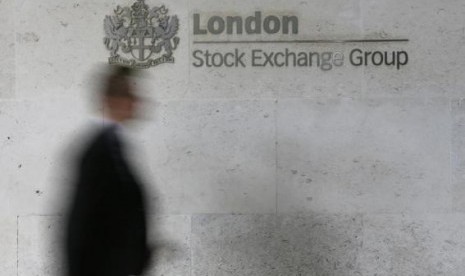 A man walks past the London Stock Exchange in the City of London October 11, 2013.