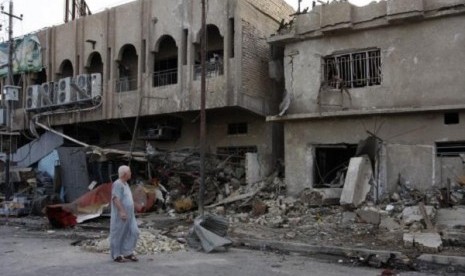 A man walks past the site of Wednesday's car bomb attack in Baghdad May 29, 2014. 